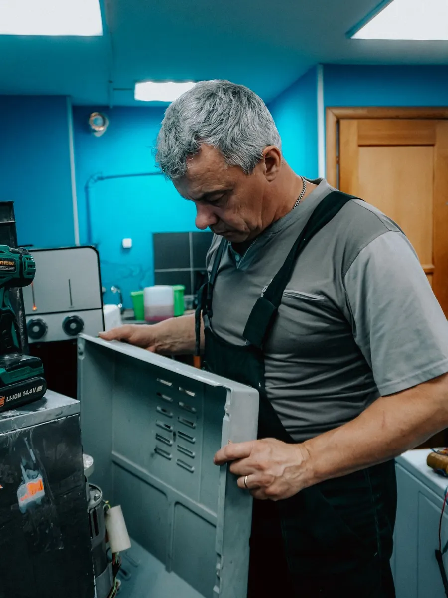 Técnico revisando el panel trasero de una lavadora