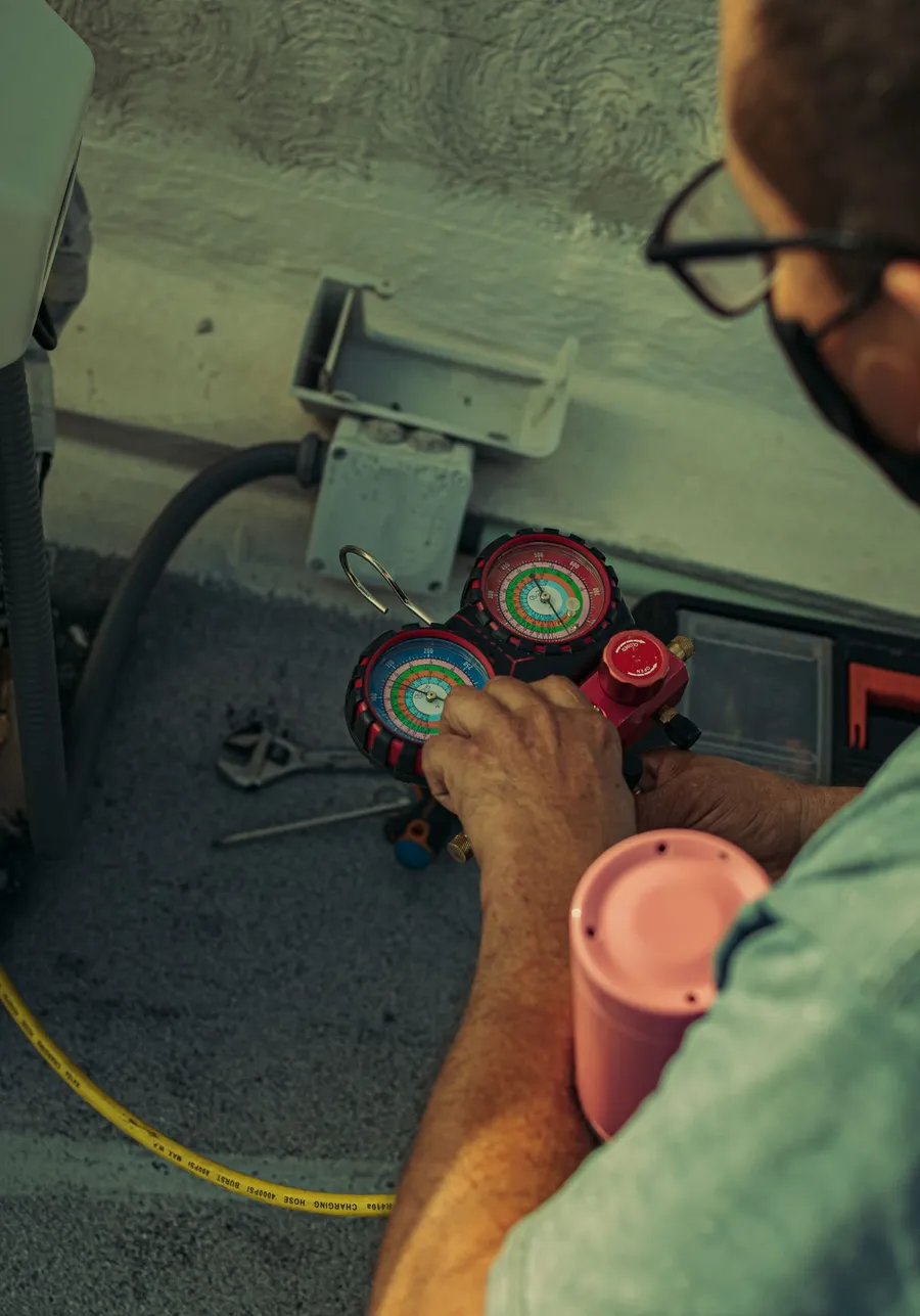 Técnico revisando la presión de refrigerante en un equipo de refrigeración